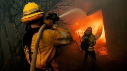 Firefighters try to control the spread of the Mountain Fire burning a structure in Camarillo, California, on November 6.