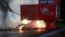 Vancouver Police work to put out a fire at a ballot box in Vancouver, Washington, on Monday.